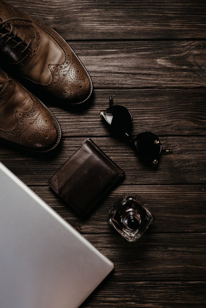 team-04 Elegant flat lay showcasing men's leather shoes, sunglasses, wallet, and perfume.